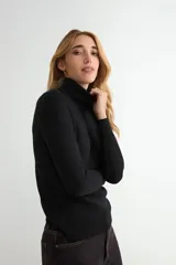 Polera de cuello alto y manga larga, confeccionada en tejido de punto fino con un diseño ajustado al cuerpo.