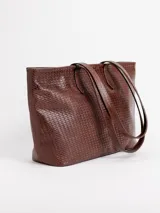 Cartera shopper grande de cuero color beige con diseño trenzado. Cuenta con asas largas de hombro, cierre superior y forro interior con bolsillos.