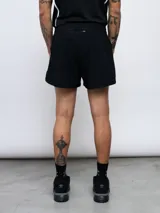 Short deportivo negro de poliéster y elastano, con logo de Umbro estampado en blanco en la pierna izquierda.