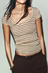 Camiseta de corte ajustado con escote redondo y manga corta, confeccionada en tejido de punto con lana. Presenta un diseño de rayas horizontales en tonos beige y marrón.