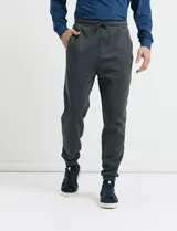Pantalón jogging de tejido circular con cintura elástica y cordón ajustable. Presenta puños elastizados en el ruedo y bolsillos laterales.