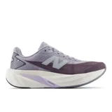 Championes de running New Balance FuelCell Rebel v5, color lila con entresuela blanca y detalles en morado. Diseño aerodinámico de malla transpirable con la característica 'N' en el lateral y tecnología de amortiguación FuelCell.