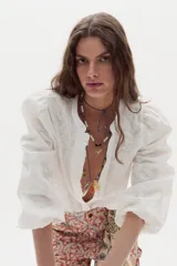 Camisa blanca de algodón con diseño jacquard sutil, cuello mao con ribete de volados y mangas abullonadas tres cuartos.
