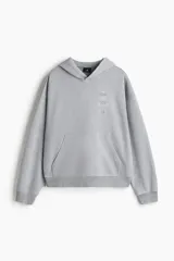 Sudadera con capucha y bolsillo canguro, confeccionada en algodón pesado con efecto lavado en tono gris claro. Presenta un estampado vertical minimalista en el pecho con números romanos y texto.
