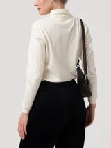 Chomba de manga larga color beige, confeccionada en piqué de algodón pima. Presenta cuello camisero clásico, tapeta con botones tono a tono y pequeño parche bordado en el pecho.