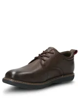 Zapato casual Hush Puppies modelo Bolo, confeccionado en cuero color marrón oscuro. Presenta cierre con cordones, suela de EVA flexible y diseño estilizado con costuras visibles en el borde de la suela.