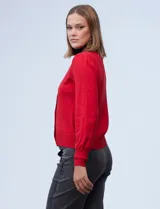 Cardigan rojo tejido en hilado fino, con escote en V y abertura central con botones metálicos.