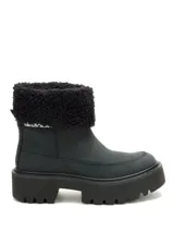 Bota de caña media color negro, confeccionada en nubuck, con cuello de pelo sintético y suela de plataforma dentada de goma.