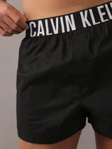 Pack de dos bóxer Calvin Klein de algodón elástico, uno negro y otro azul petróleo, con cinturilla elástica con logo de la marca.