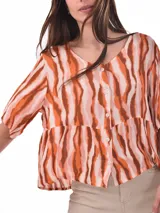 Blusa blanca de mangas cortas, con cuello redondo y abotonada al frente.