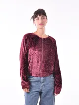 Campera negra de terciopelo con cierre frontal y apliques de lentejuelas plateadas formando líneas verticales.