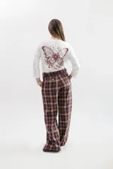 Pantalon de corte sastrero con estampado de cuadros escoceses en tonos marrones, bordo y blanco. Presenta tiro medio, bolsillos laterales con detalle de vivo en color bordo y pretina en material símil gamuza al tono.