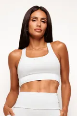 Top deportivo de alto rendimiento con diseño de espalda nadador, confeccionado en tejido técnico con protección UV50+. Presenta un bolsillo interno en el forro frontal y detalles reflectivos.