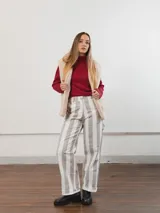 Pantalón de tiro alto con rayas verticales grises y blancas, corte recto y ruedo con dobladillo.