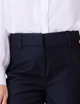 Pantalon de corte wide leg y tiro alto, con cintura estructurada, pasadores para cinturon y cierre frontal con gancho. Presenta bolsillos laterales de ojal y bolsillos traseros simulados, confeccionado en un tejido con caida fluida.