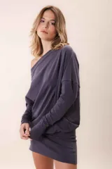 Vestido corto color gris oscuro, con escote asimétrico dejando un hombro al descubierto, mangas largas y corte holgado.