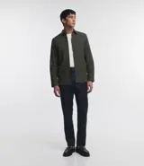 Camisa de manga larga confeccionada en tricolina de algodón, con cuello inglés, cierre frontal de botones y puños abotonados. Diseño liso y versátil.