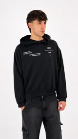 Hoodie negro de corte holgado con capucha y estampado gráfico en el pecho con texto en color blanco.
