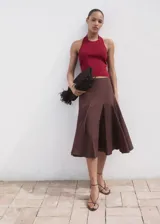 Top de punto fino con cuello halter y espalda descubierta con detalle de aro metálico. Diseño entallado sin mangas.