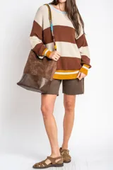 Bolso tipo shopper de tamaño maxi, confeccionado en material efecto gamuza marrón con base en cuero sintético oscuro. Cuenta con una correa ajustable y desmontable trenzada en varios colores.