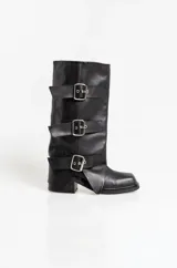 Botas de caña media en cuero negro, con diseño holgado y tres correas horizontales con hebillas metálicas ajustables. Poseen taco cuadrado bajo y punta redondeada.