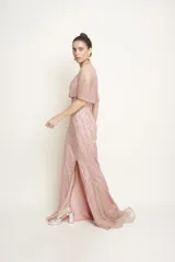 Vestido largo de tul color rosado, con sobrecapa corta y diseño entallado, íntegramente bordado con perlas y piedras.