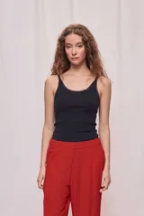 Musculosa básica negra de calce ajustado, confeccionada en tejido acanalado con escote redondo y breteles finos.