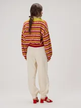 Cardigan crop de punto de algodón con mangas semi-abultadas, hombros caídos y puños acanalados. Presenta un diseño de rayas horizontales multicolor con gráficos en miniatura y cierre frontal de botones.