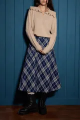 Falda midi de corte evasé con estampado de cuadros en tonos azul, blanco y gris. Presenta una caída fluida y diseño atemporal.