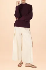 Suéter de punto con textura, color púrpura, de cuello alto y manga larga con puños ajustados.