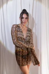 Vestido corto confeccionado en tul y lycra con estampado animal print de serpiente, escote en V pronunciado y mangas largas con diseño acampanado.