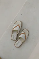 Sandalias de cuero color beige con estampado craquelado y tiras cruzadas color marrón.