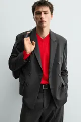 Blazer de corte regular confeccionada en tejido con lana, con diseño de botonadura cruzada. Presenta cuello con solapas de pico, manga larga con puños abotonados, bolsillos de solapa en la cadera y abertura central en la espalda.