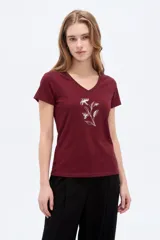 Remera de algodón bordó con cuello en V, mangas cortas, ajuste al cuerpo y diseño estampado de flores en tono plateado.
