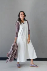 Vestido blanco de gabardina de algodón, corte evasé, sin mangas, con cuello redondo y bolsillo delantero.