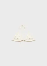 Top de bikini blanco con apliques metálicos, tirantes finos y cierre de lazos ajustables.