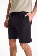 Bermuda deportiva sin friza color azul marino, con cintura elástica con cordón ajustable y bolsillos laterales.