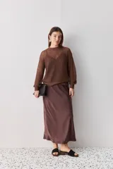 Sweater calado de punto negro, con cuello redondo y mangas largas, de diseño liviano ideal para superposiciones.