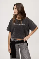 Remera de fit amplio con mangas cortas y cuello redondo, efecto lavado de color negro con estampa frontal con aplicación de strass.