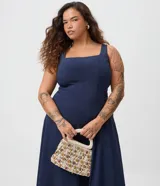 Vestido midi evasé de color azul marino, confeccionado en bengalina. Presenta escote cuadrado, diseño sin mangas, recortes verticales estructurados y una falda amplia.