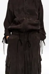 Pantalón cargo de corte barrel color marrón, confeccionado en mezcla de algodón, con bolsillos laterales con fuelle y cintura ajustable con cordón.