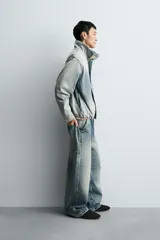 Cazadora relaxed fit de denim de algodón con efecto lavado degradado de azul a blanco. Tiene cuello subido, manga larga, bolsillos laterales en la costura de la cadera y acabados con elástico interior. El cierre frontal es con cremallera oculta por una solapa con botones a presión.