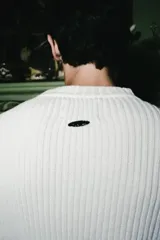 Sweater de tejido acanalado en color blanco, con cuello redondo y logo bordado en el frente.
