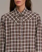 Camisa western a cuadros marrones, blancos y negros, con canesú y botones marrones.