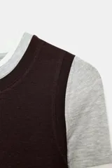 Camiseta de manga larga con diseño de capas superpuestas que crea un efecto triple. Presenta cuello redondo, corte ajustado y combinación de colores en tonos blanco, gris y negro.