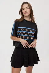 Falda corta blanca con diseño de volados escalonados y cintura elastizada, de silueta fluida y liviana.