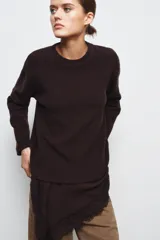 Vestido de punto con cuello redondo y manga larga, que presenta un bajo asimétrico de satén con detalle de encaje a tono.
