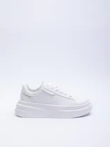 Zapatillas blancas acordonadas con base de plataforma y recortes texturizados.