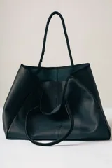 Bolso tipo tote de gamuza color marrón con detalles de bordes y asas en cuero negro.