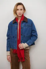 Chaqueta de jean azul con cuello de gamuza sintética marrón, bolsillos delanteros y botones frontales.